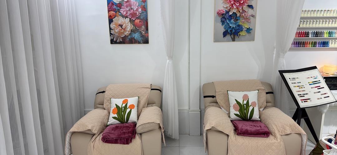 Hai ghế recliner màu kem với gối hoa tulip tại Ôlala